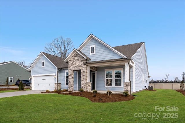 view of front of house with fence, stone siding, a front lawn, an attached garage, and driveway