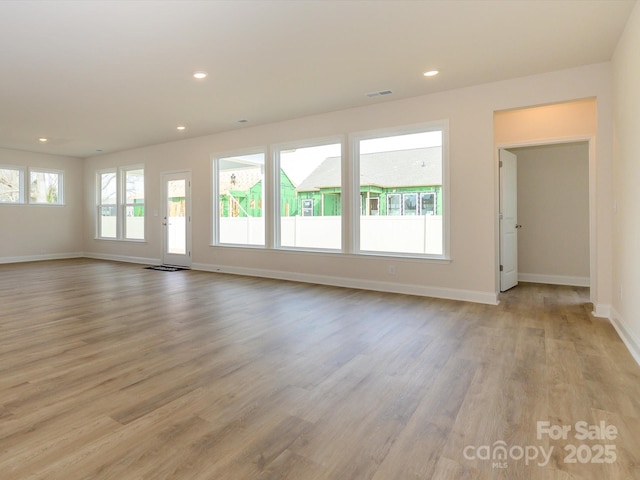 unfurnished living room featuring light wood-type flooring, baseboards, visible vents, and recessed lighting