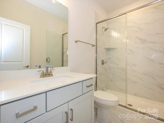 bathroom featuring toilet, vanity, and a marble finish shower