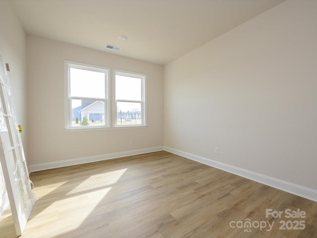 unfurnished room with visible vents, baseboards, and light wood-type flooring