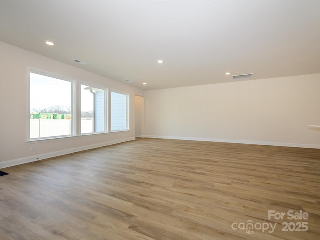 spare room featuring light wood-style floors, visible vents, and recessed lighting