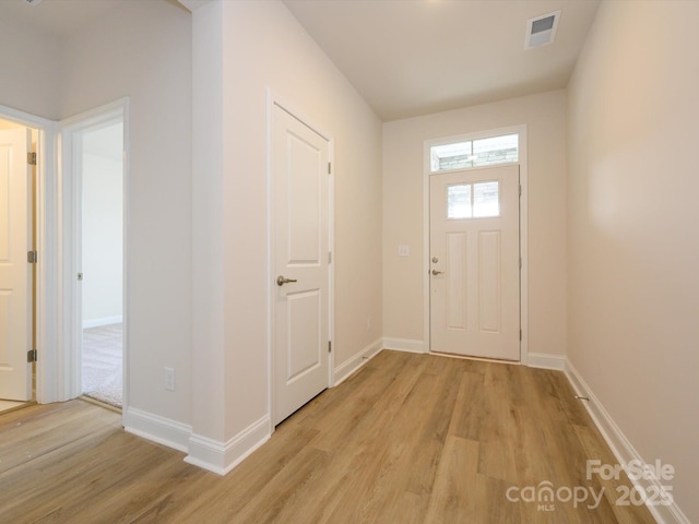 entryway with light wood-style floors, baseboards, and visible vents