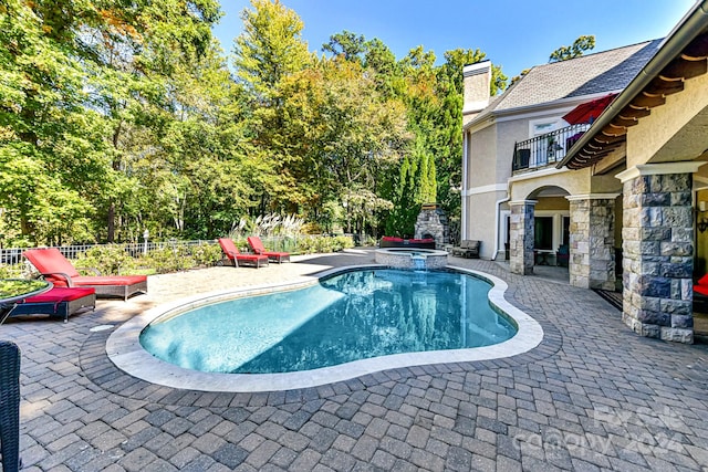 view of pool with a patio and an in ground hot tub