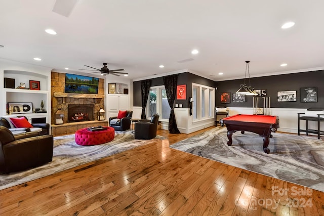 game room with light hardwood / wood-style floors, billiards, a fireplace, crown molding, and built in features