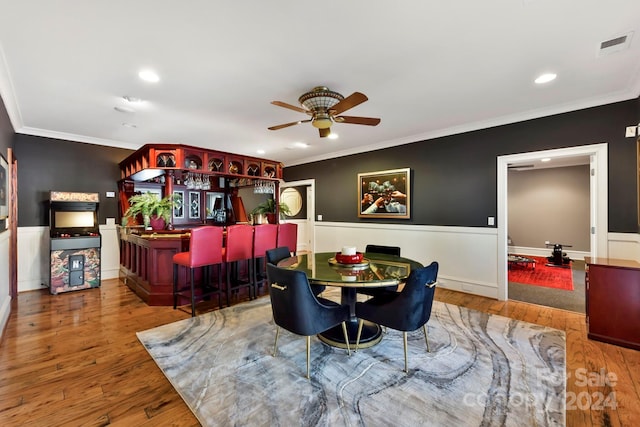 dining area with ornamental molding, light wood-type flooring, and ceiling fan