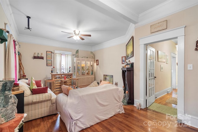 interior space with wood-type flooring, ornamental molding, and ceiling fan