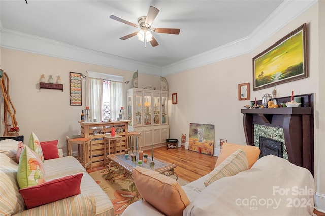 living room featuring light hardwood / wood-style floors, ceiling fan, and crown molding