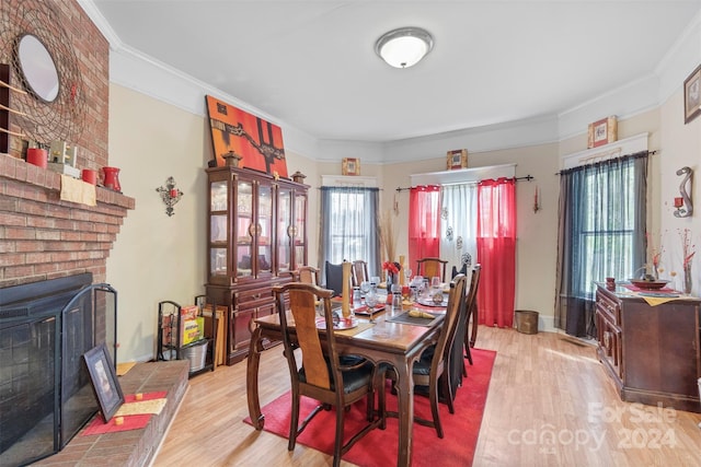 dining space with a fireplace, light hardwood / wood-style floors, a wood stove, and a healthy amount of sunlight