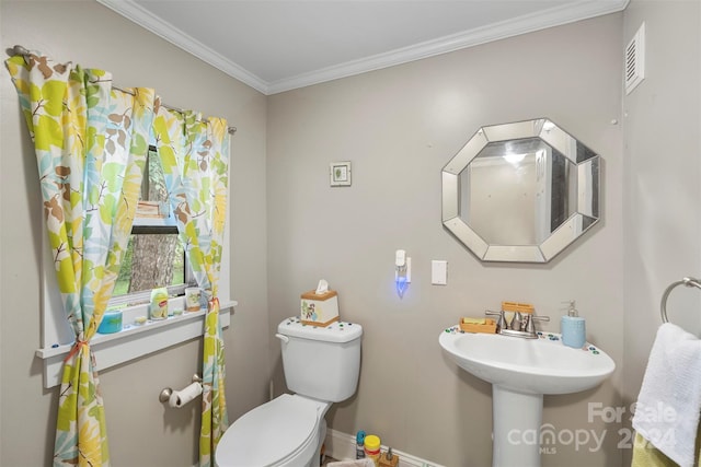 bathroom featuring crown molding and toilet