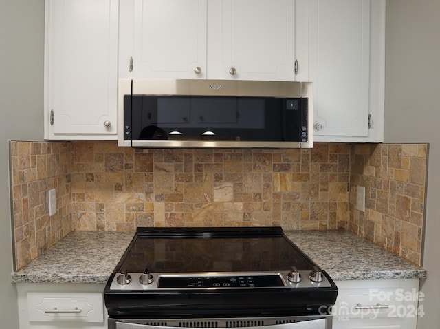 kitchen with light stone counters, white cabinets, appliances with stainless steel finishes, and decorative backsplash