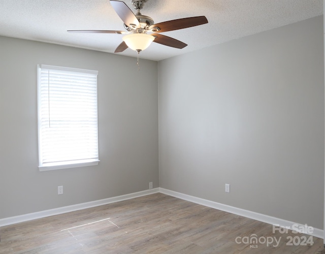 spare room featuring a textured ceiling, ceiling fan, and light hardwood / wood-style flooring