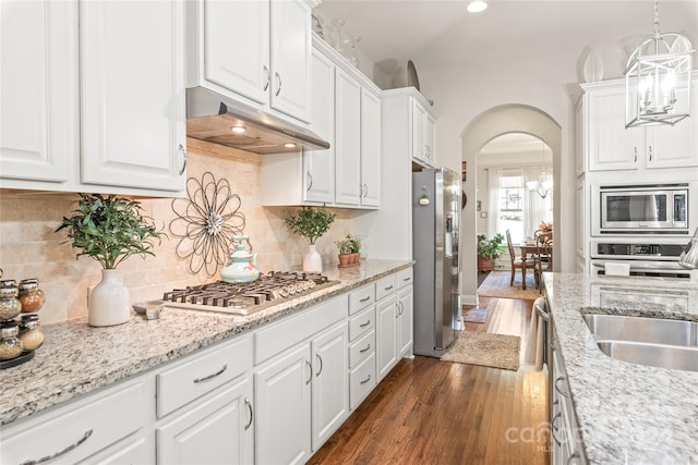 kitchen with pendant lighting, dark hardwood / wood-style flooring, sink, stainless steel appliances, and white cabinetry