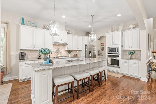 kitchen featuring appliances with stainless steel finishes, white cabinetry, and a center island with sink