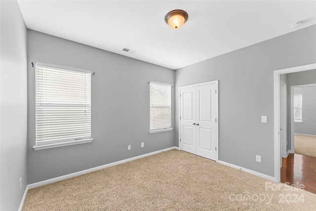 unfurnished bedroom featuring carpet floors and a closet