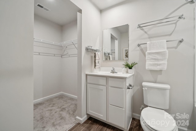 bathroom with wood-type flooring, vanity, and toilet