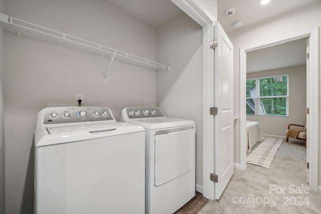 laundry area featuring light colored carpet and washing machine and dryer