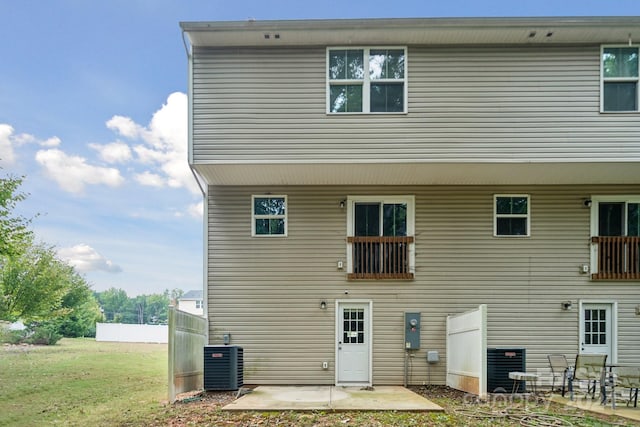 back of property with central AC, a patio area, and a yard