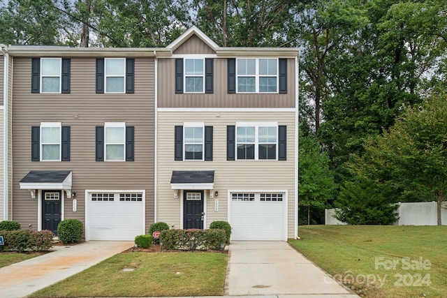 multi unit property featuring a front yard and a garage