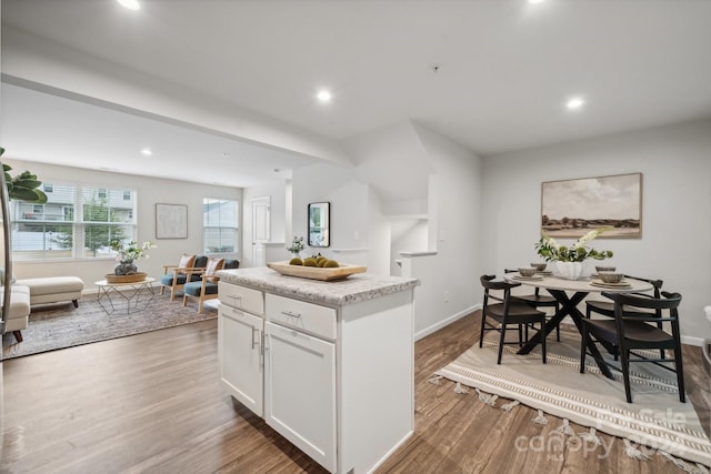 kitchen with white cabinetry, a kitchen island, and dark hardwood / wood-style flooring