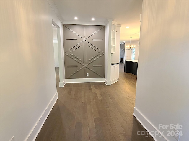 hallway featuring a notable chandelier and dark hardwood / wood-style floors