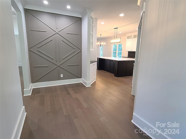 hall featuring an inviting chandelier and dark hardwood / wood-style floors