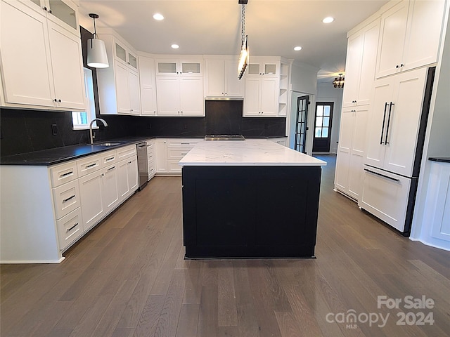 kitchen with white cabinetry, decorative light fixtures, a kitchen island, and paneled built in refrigerator