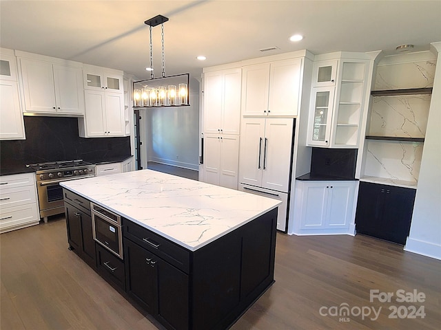 kitchen featuring high end appliances, a kitchen island, backsplash, and dark hardwood / wood-style flooring