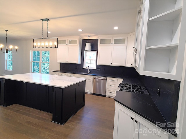 kitchen featuring a healthy amount of sunlight, appliances with stainless steel finishes, decorative light fixtures, and a kitchen island