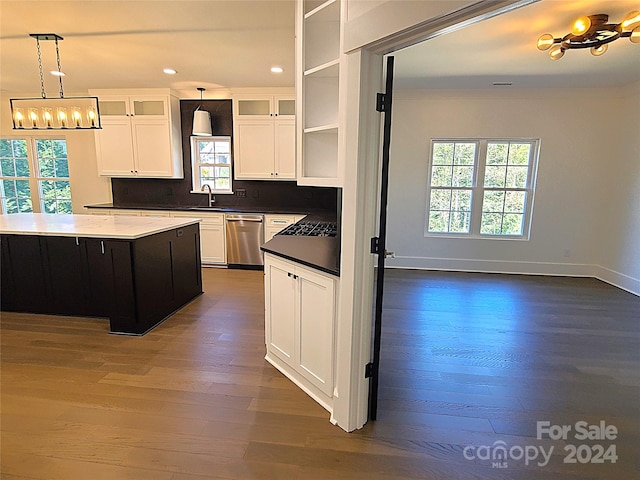 kitchen with stainless steel dishwasher, dark wood-type flooring, a kitchen island, and plenty of natural light