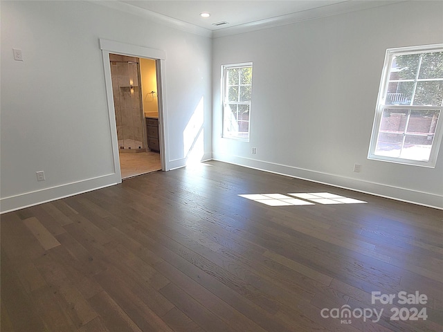 empty room with crown molding and dark hardwood / wood-style floors