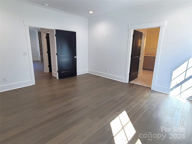 empty room with sink, ornamental molding, and dark hardwood / wood-style flooring