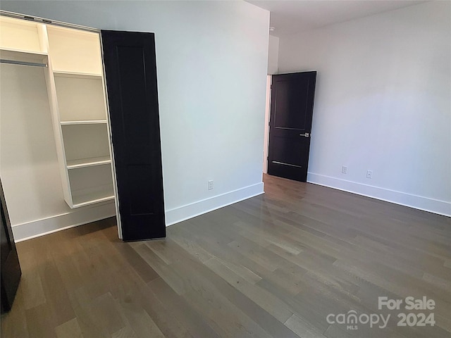 unfurnished bedroom with dark wood-type flooring