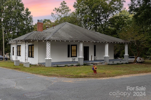 view of front facade with a lawn and a porch