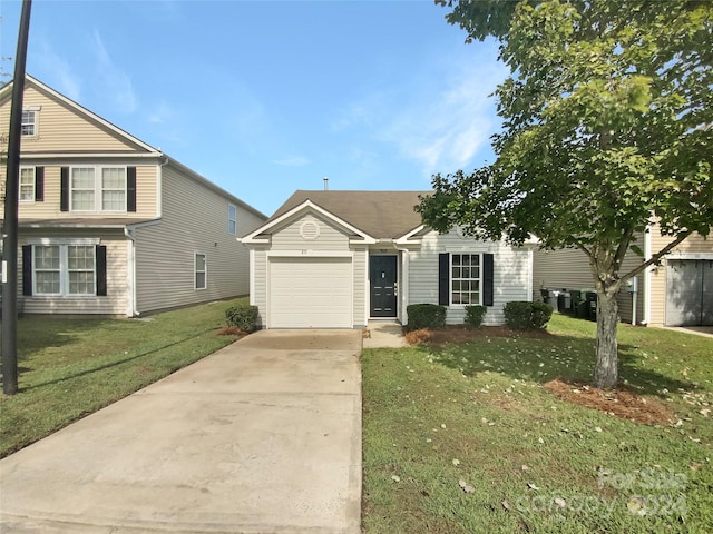 view of front of property featuring a front yard and a garage