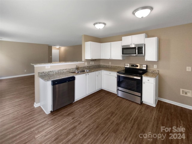 kitchen with kitchen peninsula, dark hardwood / wood-style floors, stainless steel appliances, and white cabinets