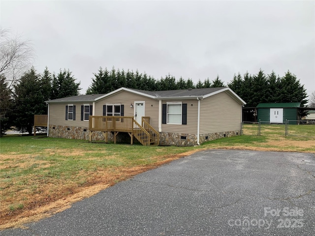 manufactured / mobile home featuring a front lawn and a deck