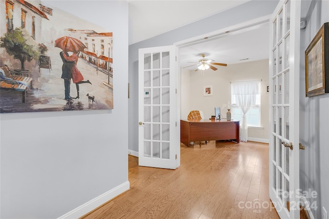 entryway with light hardwood / wood-style floors, ceiling fan, and french doors