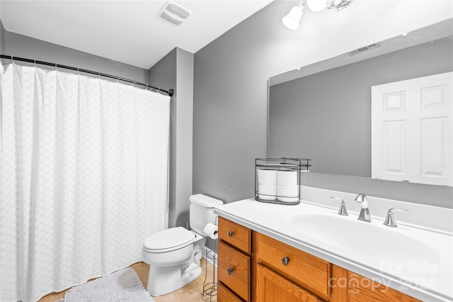 bathroom featuring a shower with shower curtain, tile patterned floors, vanity, and toilet