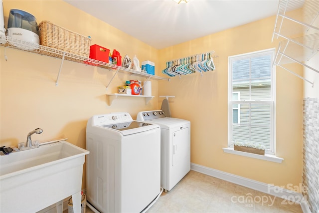 clothes washing area with separate washer and dryer and sink