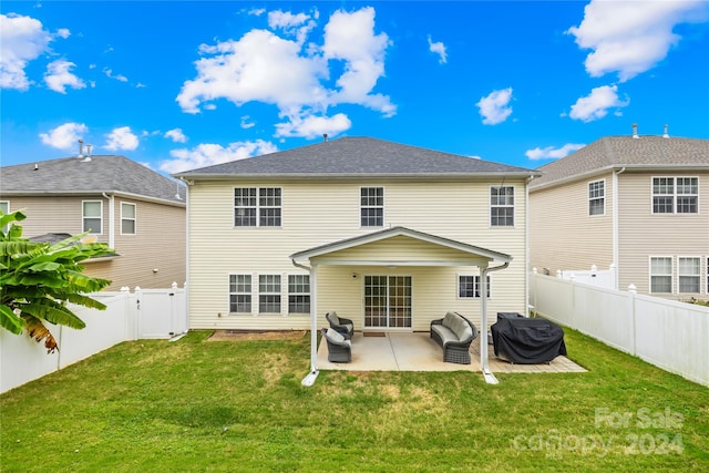 rear view of house with a patio and a yard