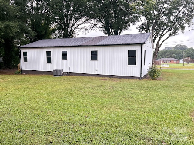 rear view of property featuring a yard and central AC