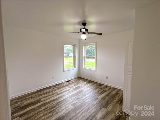 spare room with ceiling fan and dark wood-type flooring