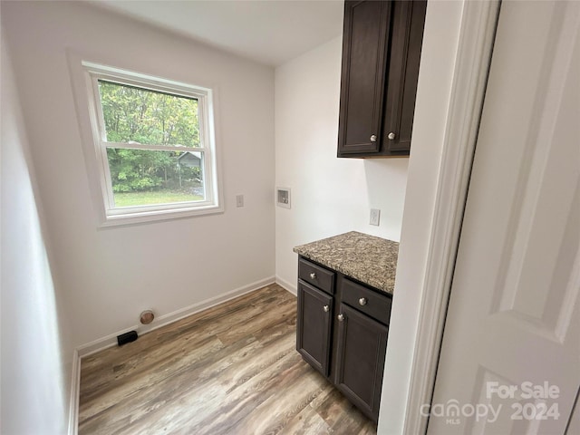 washroom featuring cabinets, hookup for a washing machine, and light wood-type flooring