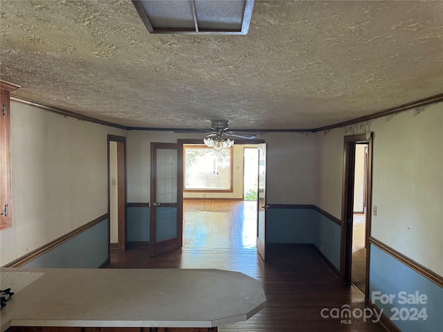 empty room featuring ceiling fan, a textured ceiling, crown molding, and hardwood / wood-style floors