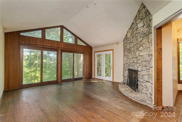 unfurnished living room featuring a textured ceiling, dark hardwood / wood-style flooring, a fireplace, and high vaulted ceiling