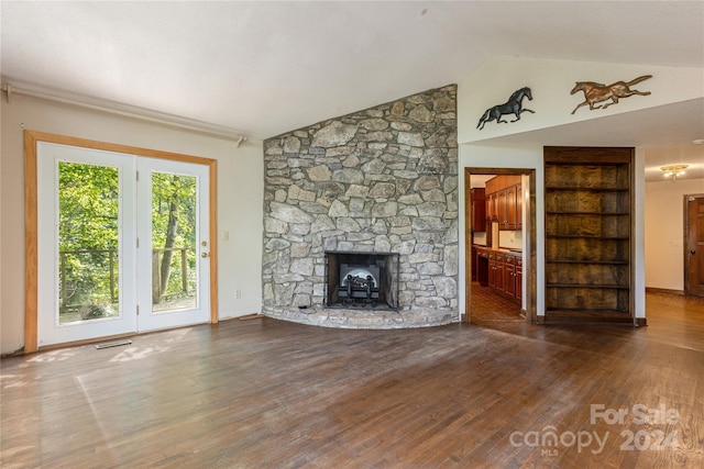 120 Pinewood Cir, Laurel Park, NC 28739 - unfurnished living room featuring visible vents, wood finished floors, a stone fireplace, and vaulted ceiling