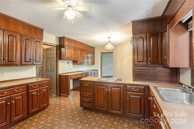 kitchen with sink, white gas cooktop, a textured ceiling, decorative light fixtures, and ceiling fan with notable chandelier