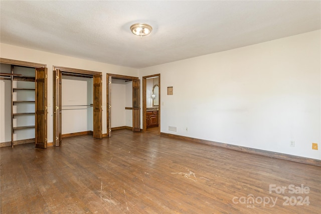 120 Pinewood Cir, Laurel Park, NC 28739 - unfurnished bedroom featuring visible vents, dark wood-style flooring, multiple closets, and baseboards