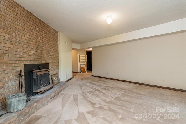 unfurnished living room featuring a textured ceiling, light colored carpet, and brick wall