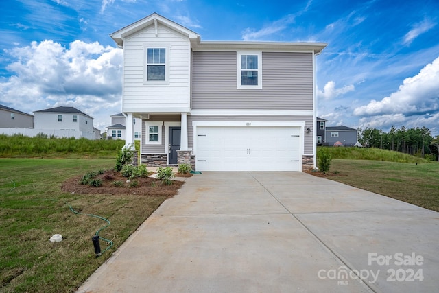 view of front of property featuring a front yard and a garage